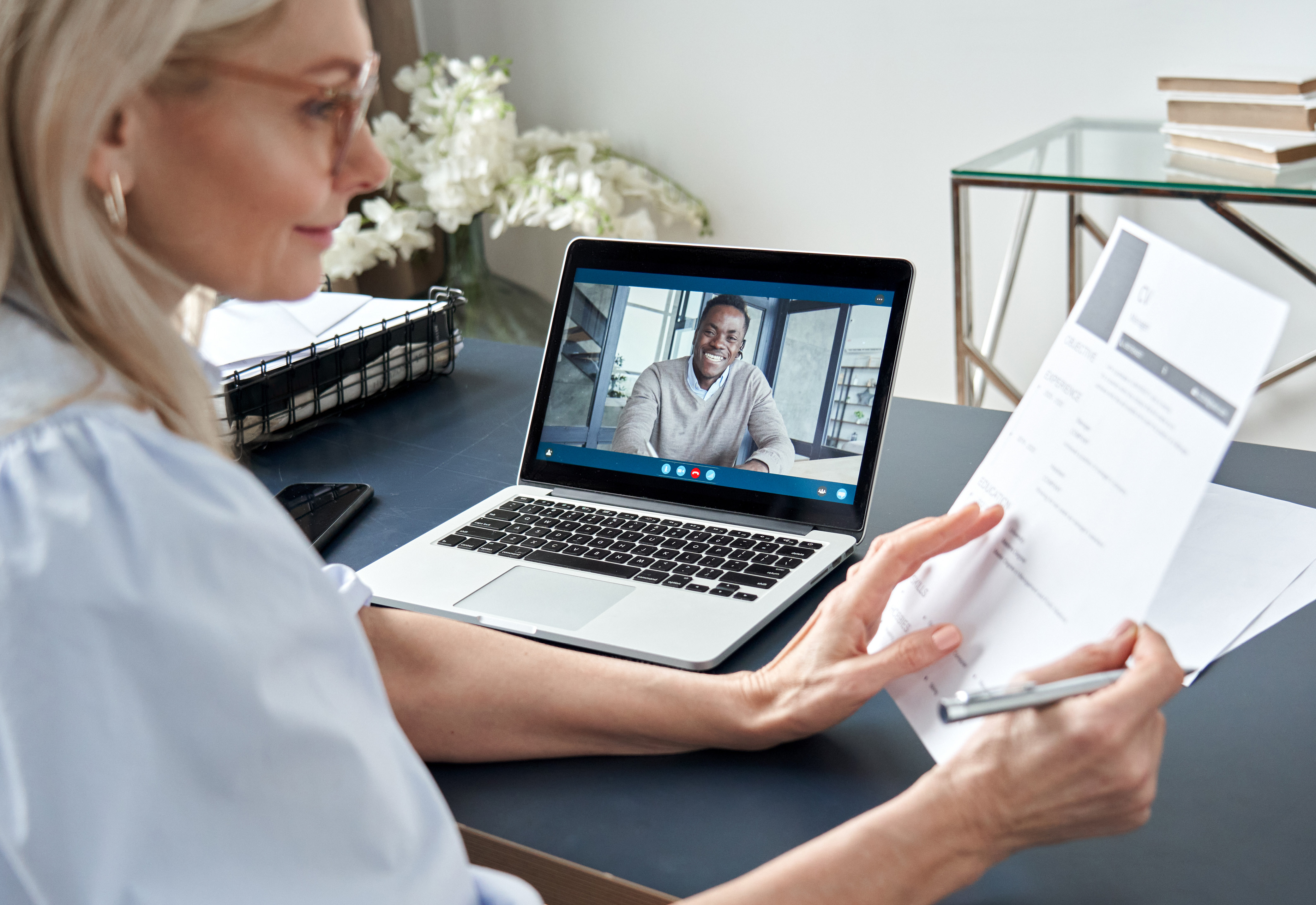 A woman conducting a virtual job interview with a candidate. 