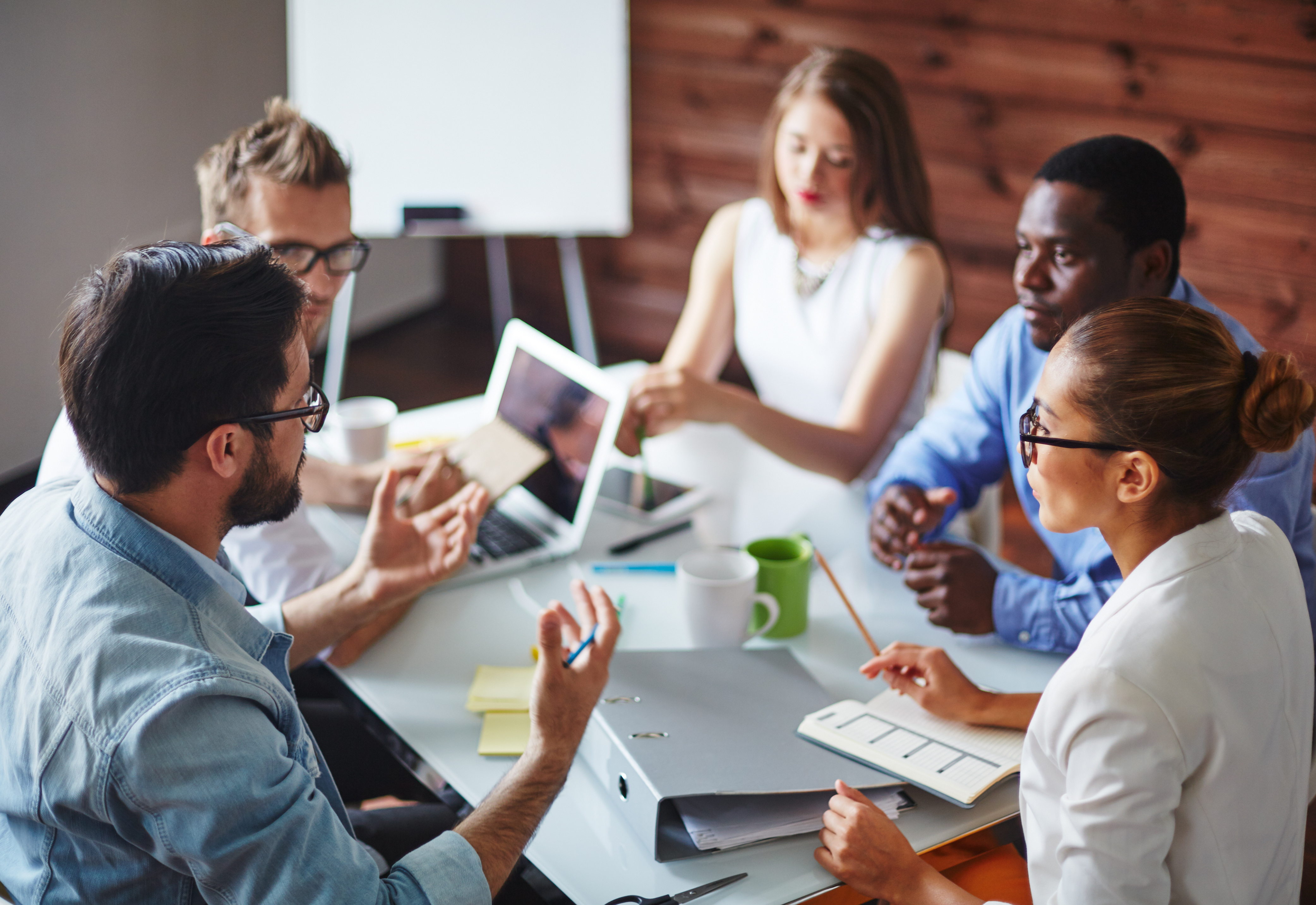 A group of people sitting around a table having a discussion