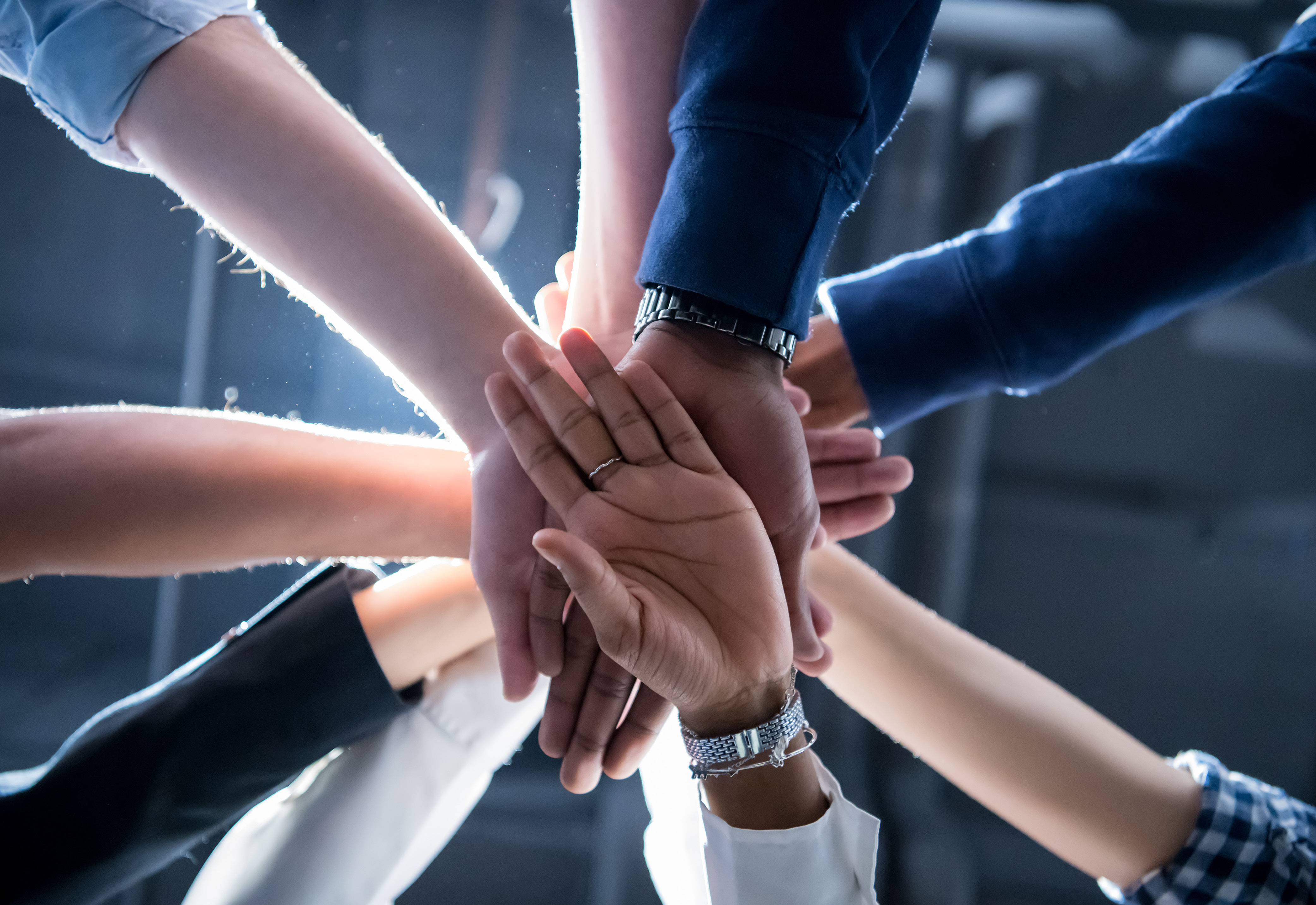 A group of people stacking their hands together