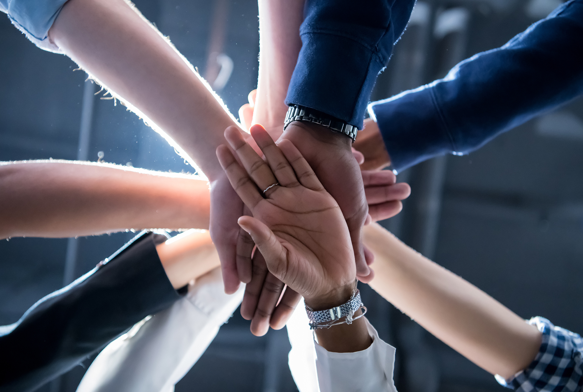 A group of people stacking their hands together