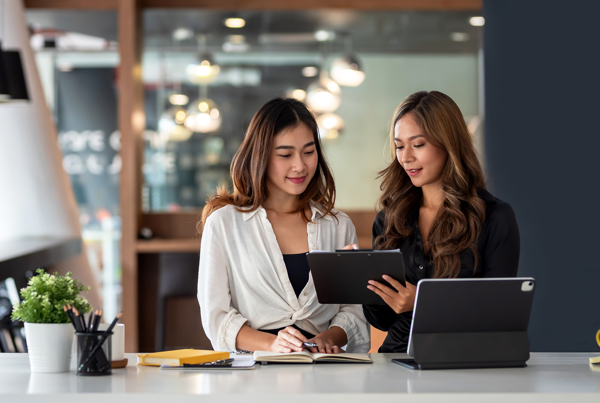 Two women in an office looking at a tablet together