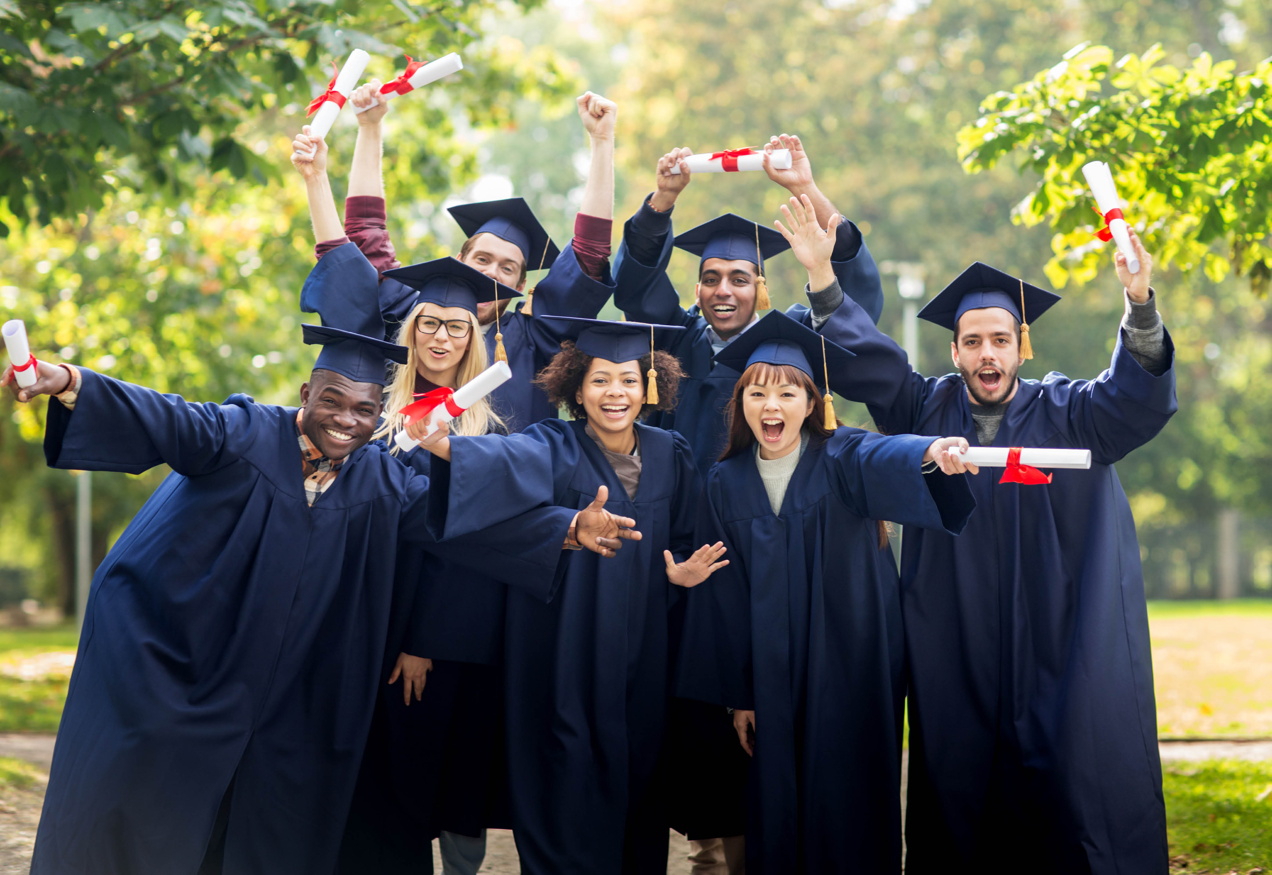 A group of college graduates posing with their diplomas