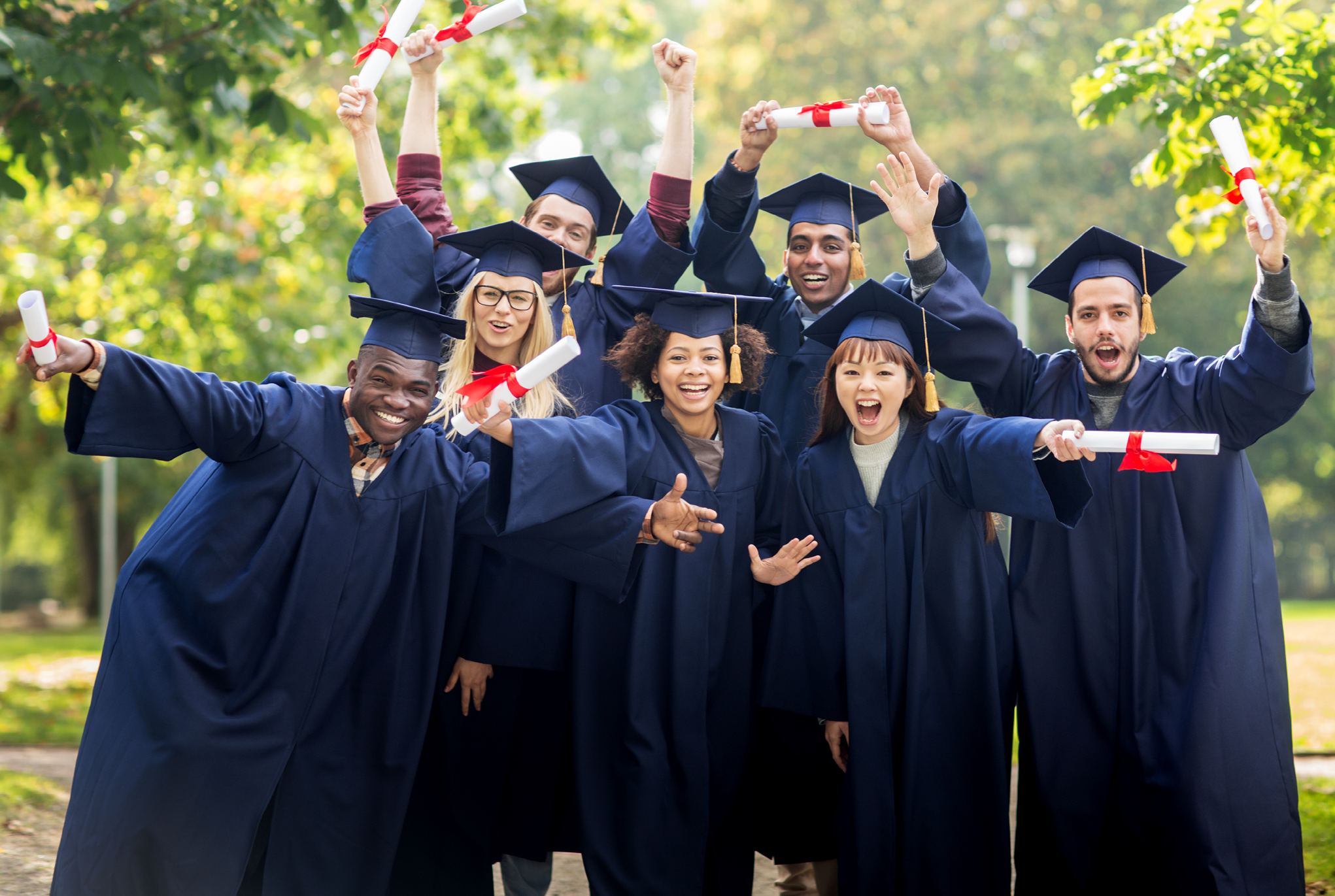 A group of college graduates posing with their diplomas