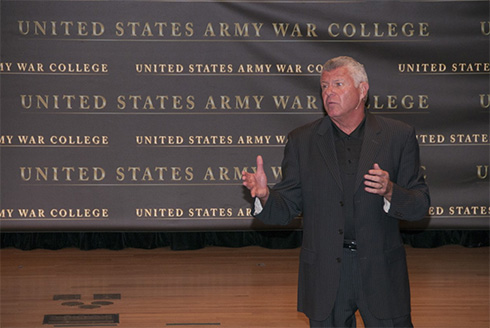 bob delaney stands on stage giving a speech