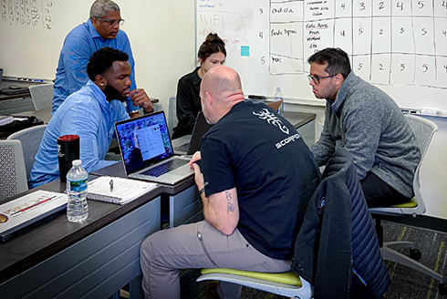 Group of CARVER students sit in class working on group project