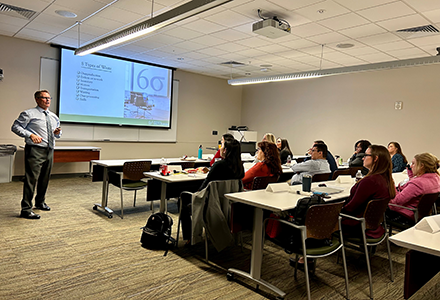 a class sits and listens to a presenter