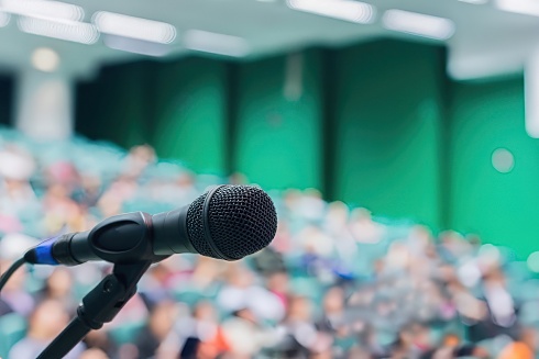 a microphone in front of a large auditorium of people 