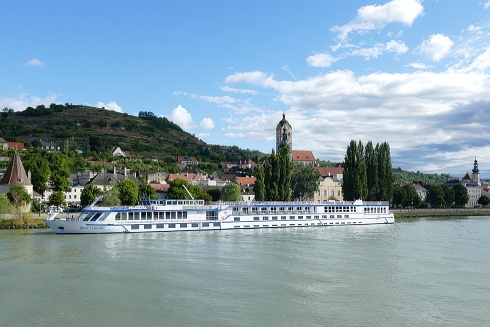 a large river boat travels in a european town