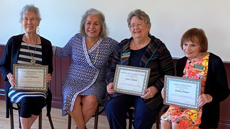 Four seated women with certificates