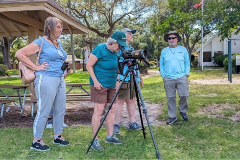 A group of seniors in a park using a premium camera to photograph
