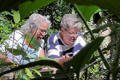 2 older women examine plants 