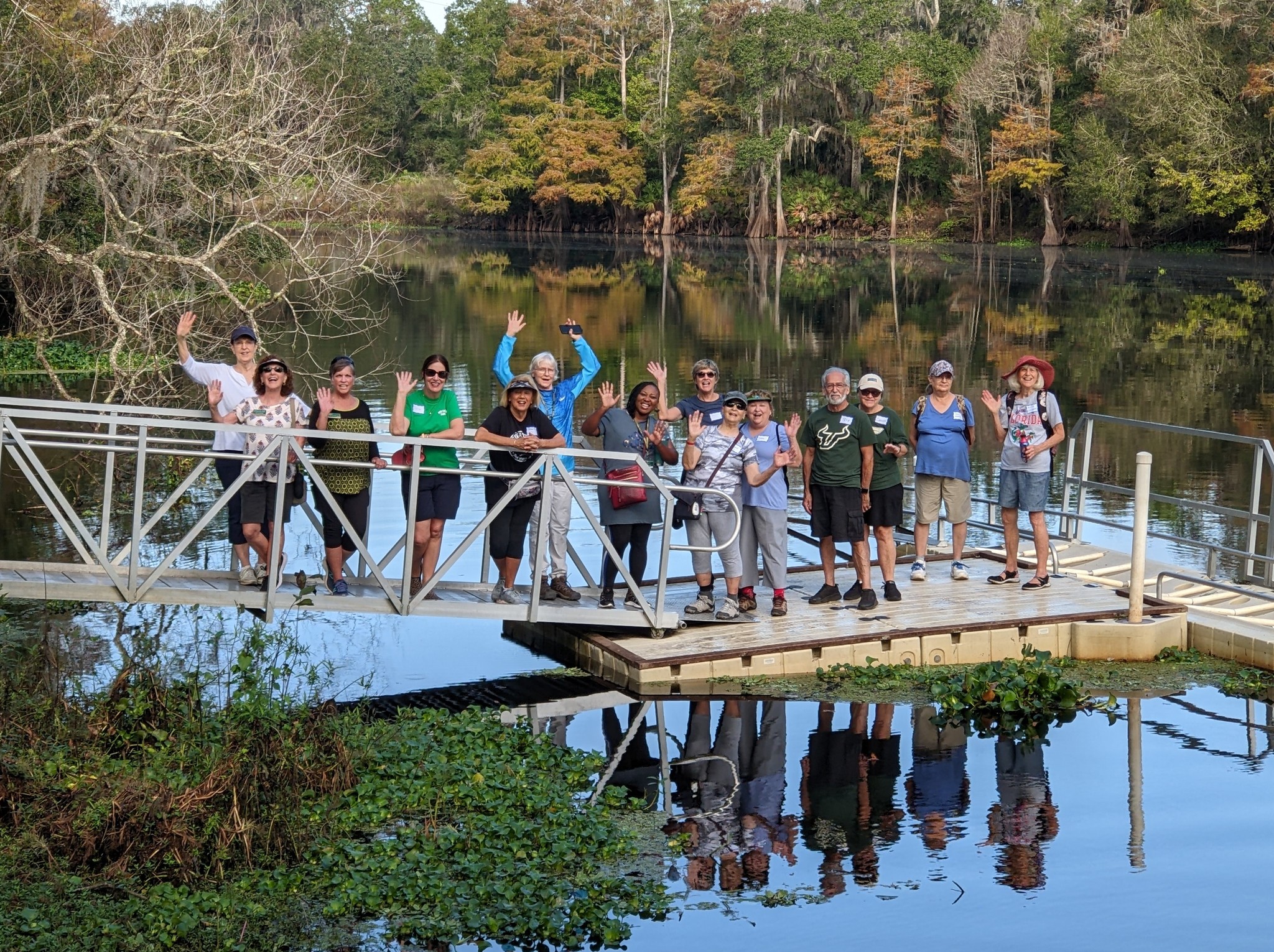 Group of OLLI members by a lake celebrating