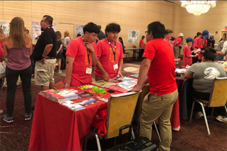 students at table with pamphlets and brochures