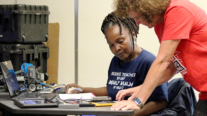 Teacher working with another teacher on a calculator