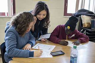 Counselor Education student helps a student during a lesson