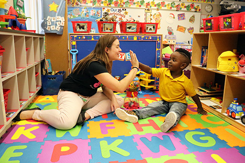 USF student in the ESE program high fives a preschool student