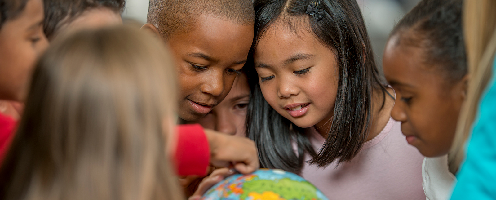 school children studying a globe