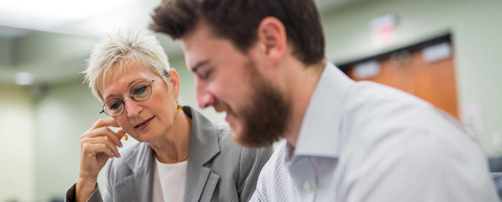 higher education administrator working with a student in a USF classroom 