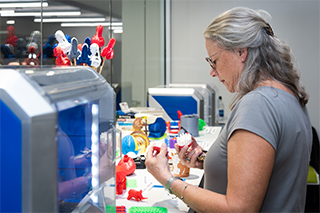 Teacher in STEM lab using a 3D printer