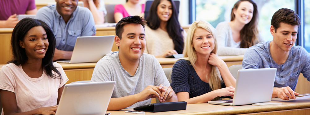 Adult students in classroom with laptops