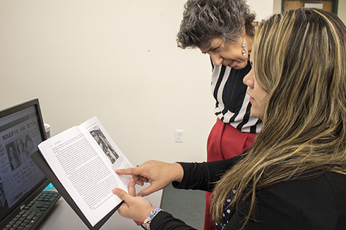 Student showing a USF staff member materials they found from their research on the Holocaust