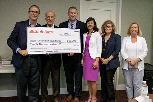 Group photo of State Farm check presentation at Gus A. Stavros Center