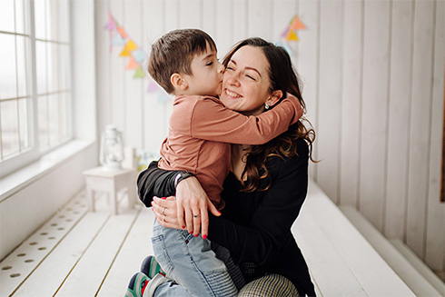 Mother hugging son at home