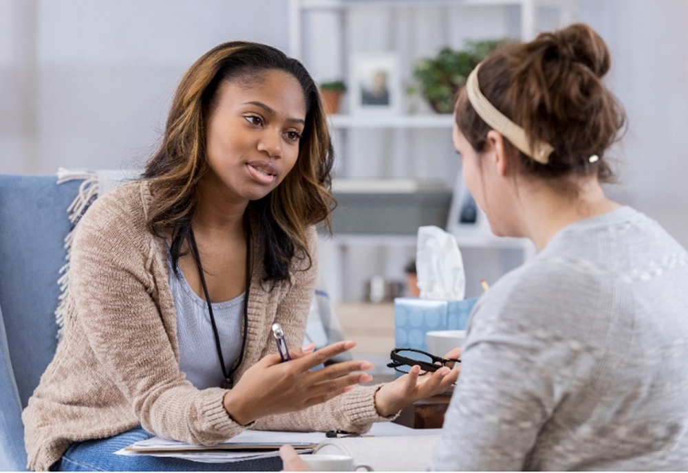 A school psychologist speaking with a teenager. 