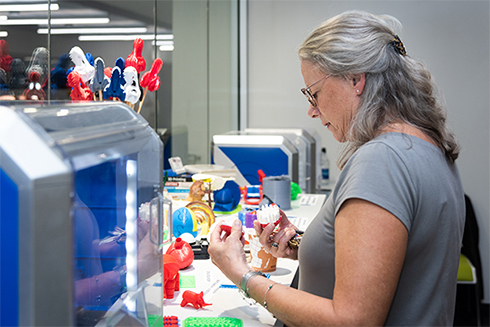 Teacher at USF St. Petersburg campus using a 3D printer