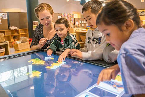 Preschool students with teacher using a Promethean tablet in a classroom