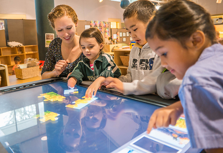 Preschool students with teacher using a Promethean tablet in a classroom