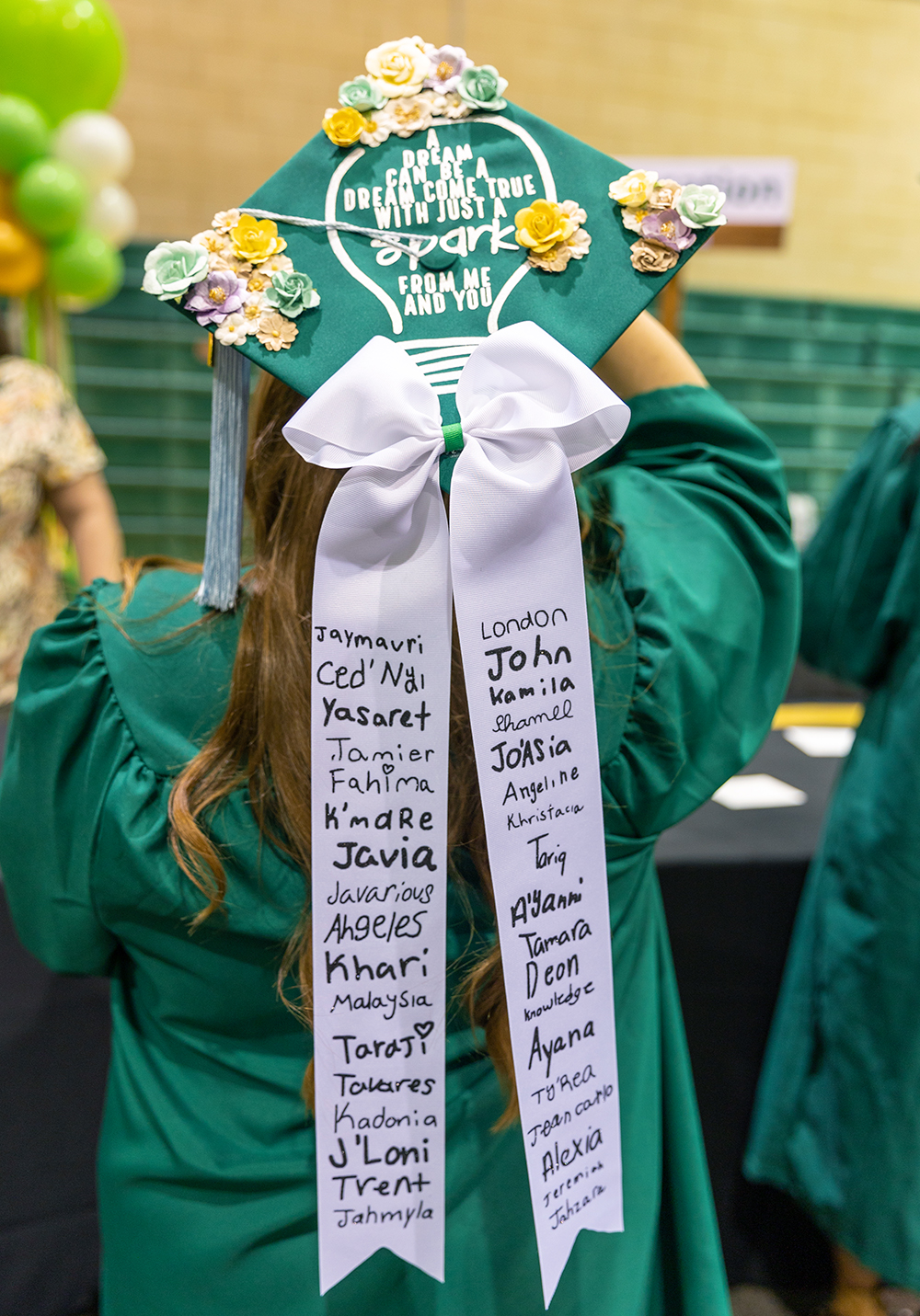 Graduation Cap decorated with student names written on an attached bow