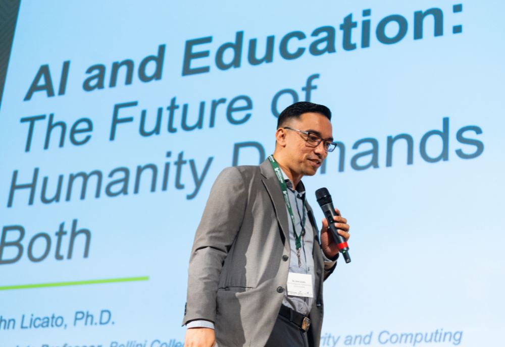 John Licato delivering a keynote address on day one of the summit (Torie Doll).