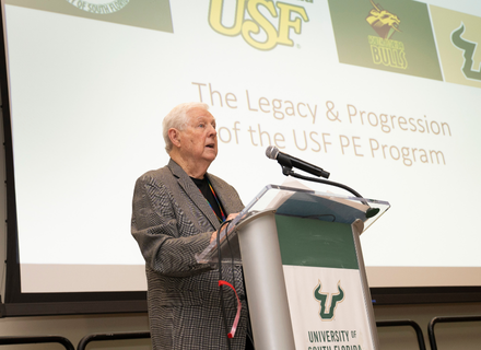 Lou Bowers speaking at the 2025 AIESEP conference moment before being honored with a "Heart of the Herd" award.
