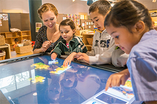 Children working on interactive table top touch screen 