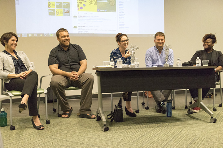 Disseration panelists sit at a table together answering questions