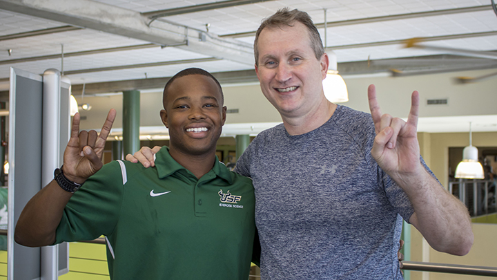 USF senior Joseph McMiller gives the USF Horns Up with College of Education Dean Robert Knoeppel