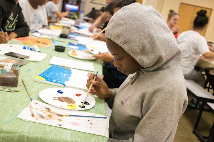 Student paints during art class at Pepin Summer Institute