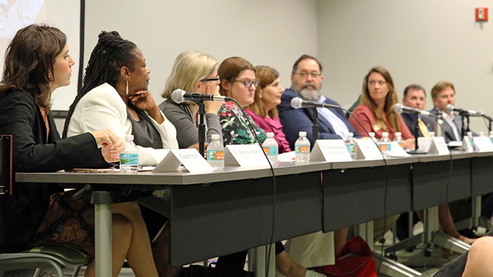 Panel of experts sit at a table during School Safety Panel event