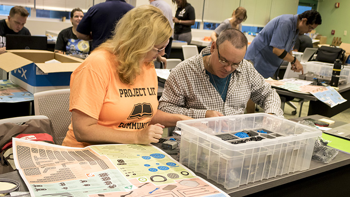 Teachers build a VEX IQ robot at robotics teacher training session at USF