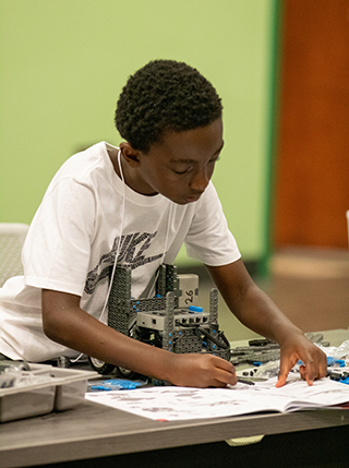 Boy building a VEX IQ robot at USF Robotics Summer Camp