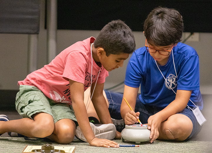 Boys programming a Roamer robot at the USF Robotics Summer Camp