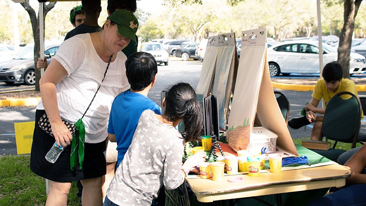 USF Professor helps students on literacy activity at local community event.