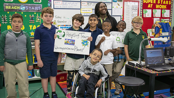 USF student teacher in a group photo with students from an ESE classroom in Tampa