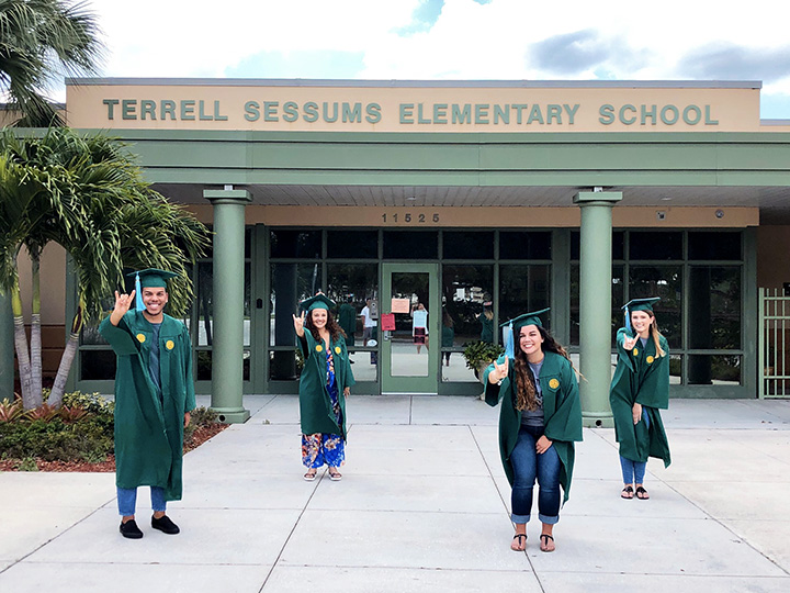 USF students in regalia outside of Sessums Elementary