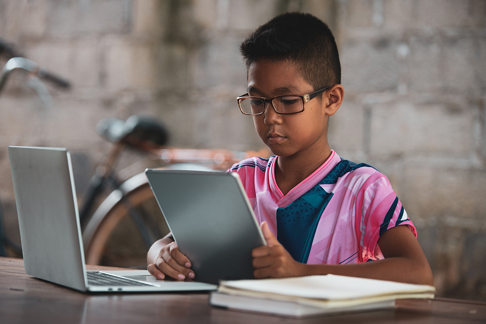 Child using laptop and tablet