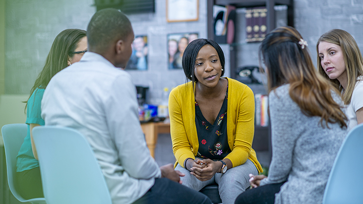 People sitting together in a circle during group therapy session