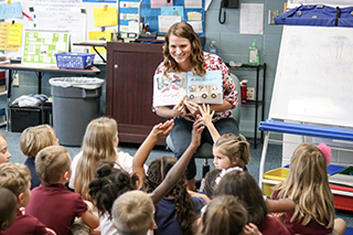 School counseling student reading to students in a classroom