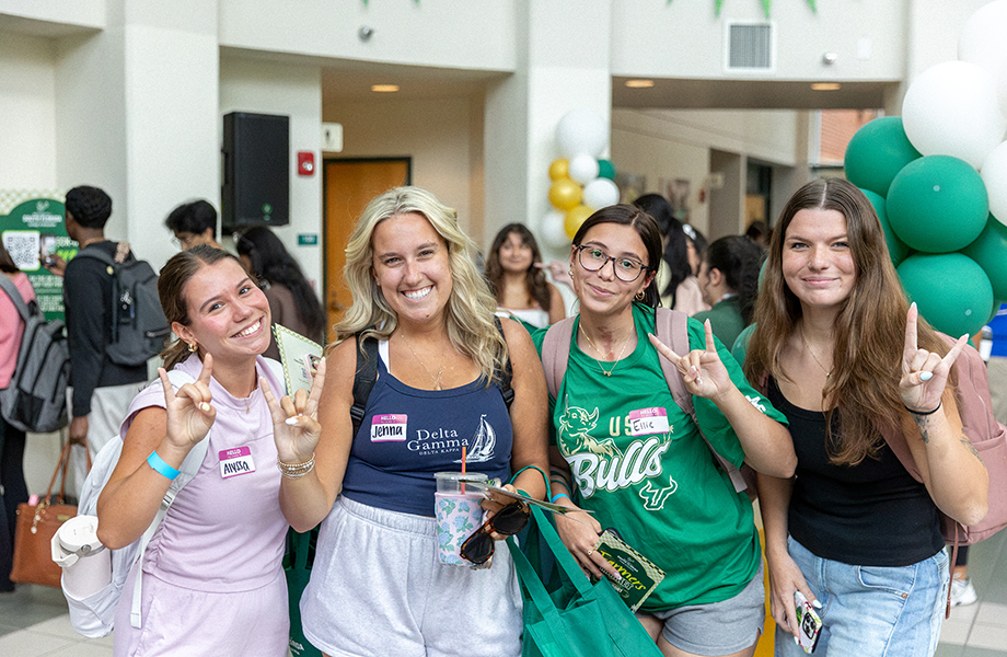 four USF women making the bull horns hand gesture