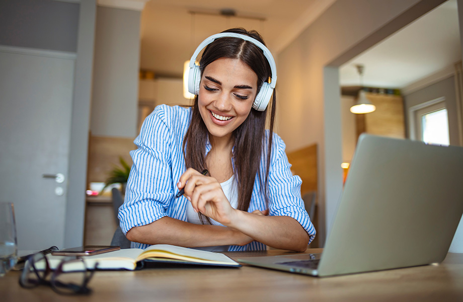 a woman smiling on a laptop
